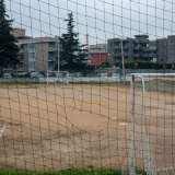 ...il terreno � malridotto e dalla recinzione, piena di buchi, si intravede da lontano uno dei camini della centrale dell'Enel in dismissione